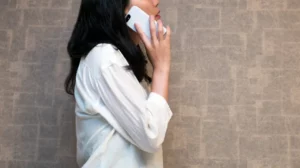 A women making a call using a white iPhone