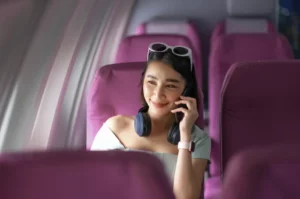 A women making a Wi-Fi call while travelling on an airplane