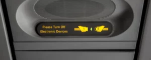 A sign saying " Tuen off all electronic devices" on Airplane